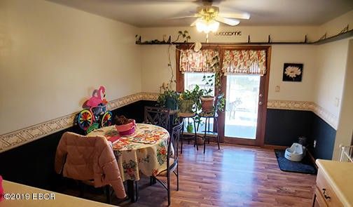 A dining room with a table and chairs and a ceiling fan.