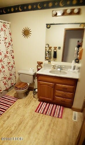 A bathroom with a toilet , sink , and mirror.