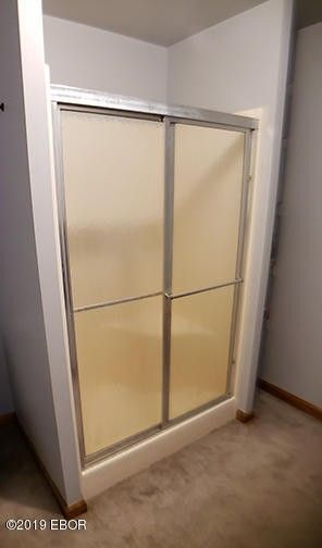 A bathroom with a sliding glass shower door.