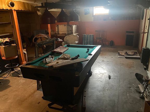 There is a pool table in the middle of a room.