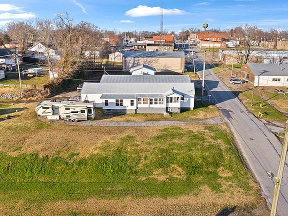 An aerial view of a house and a trailer in a small town.