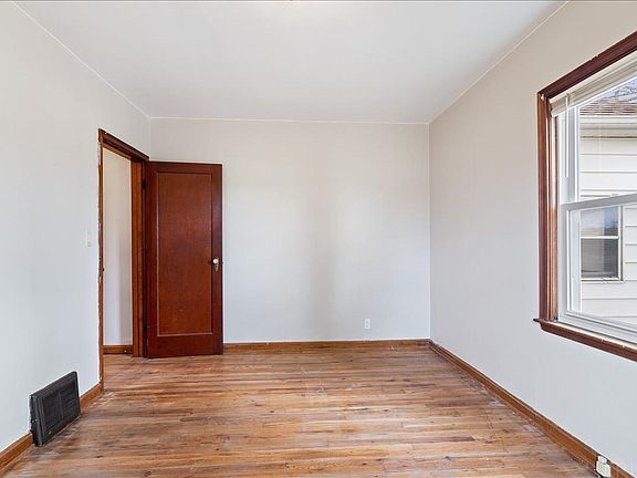 An empty room with wooden floors and a window.