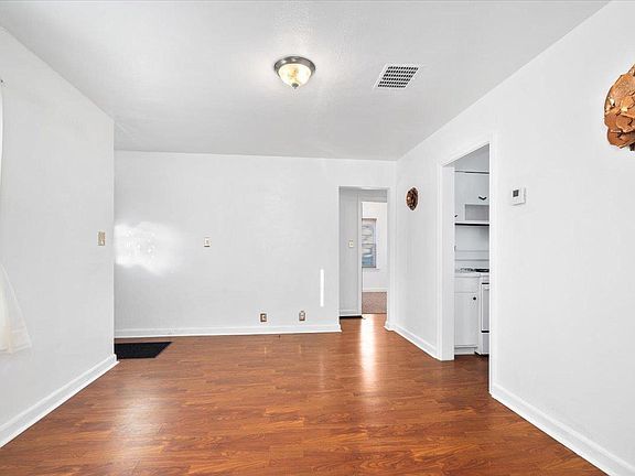 An empty room with hardwood floors and white walls