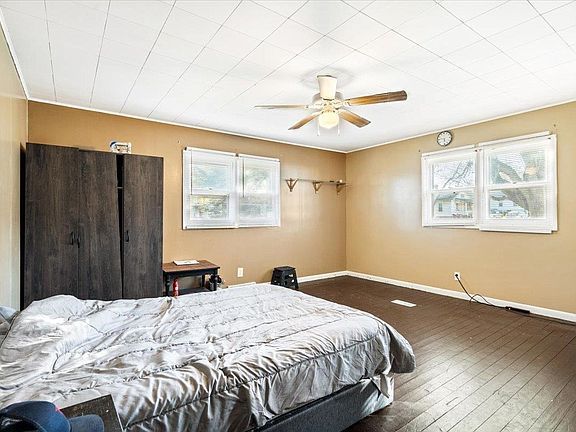 A bedroom with a bed and a ceiling fan.