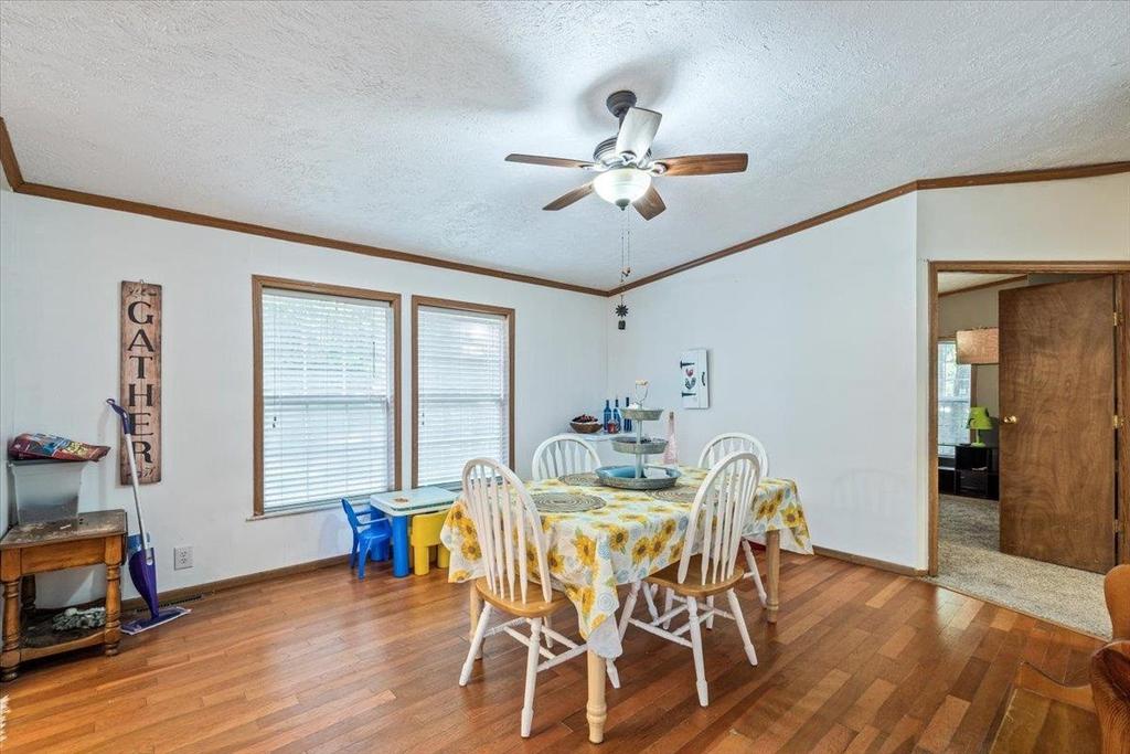 A dining room with a table and chairs and a ceiling fan