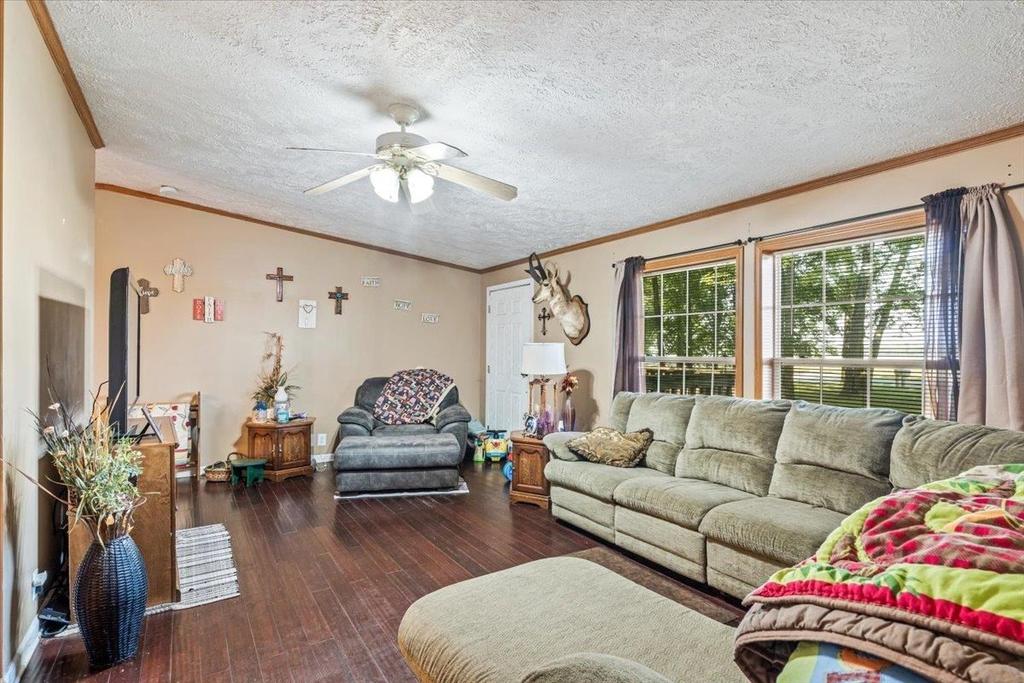 A living room filled with furniture and a ceiling fan.