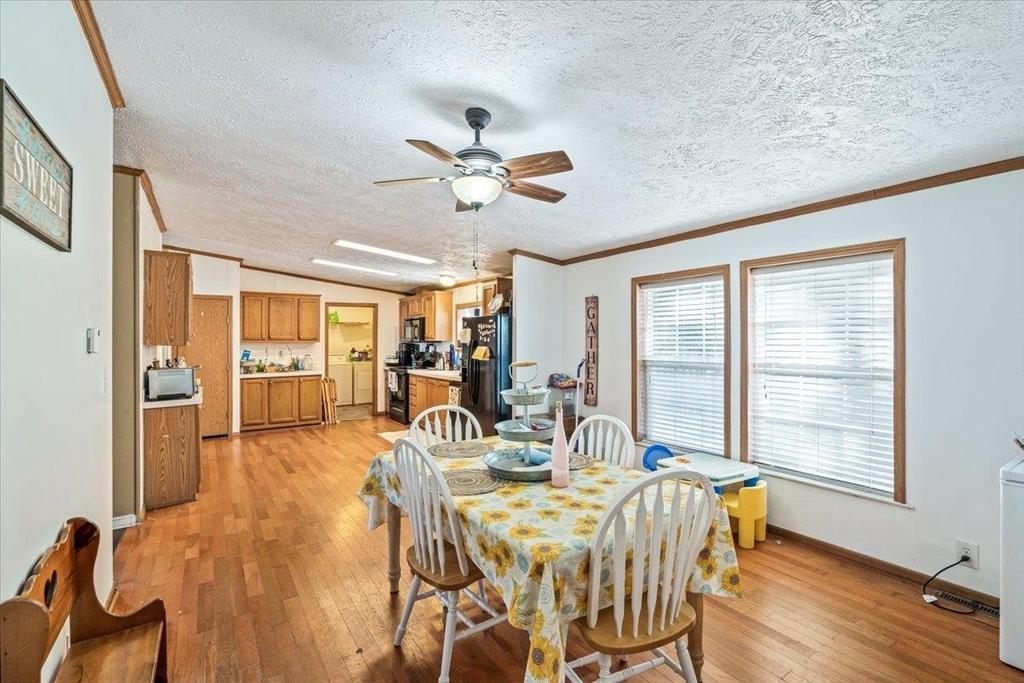 A dining room with a table and chairs and a ceiling fan.