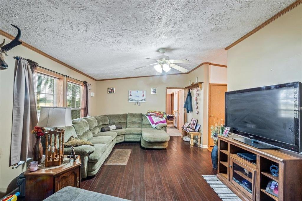 A living room with a large sectional couch and a flat screen tv.