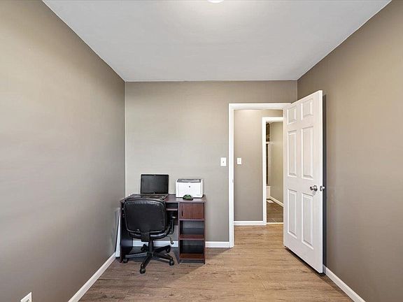 A small room with a desk and chair in it.