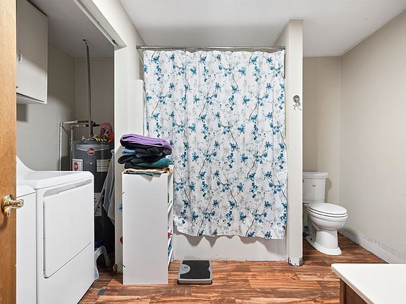A bathroom with a shower curtain and a toilet.