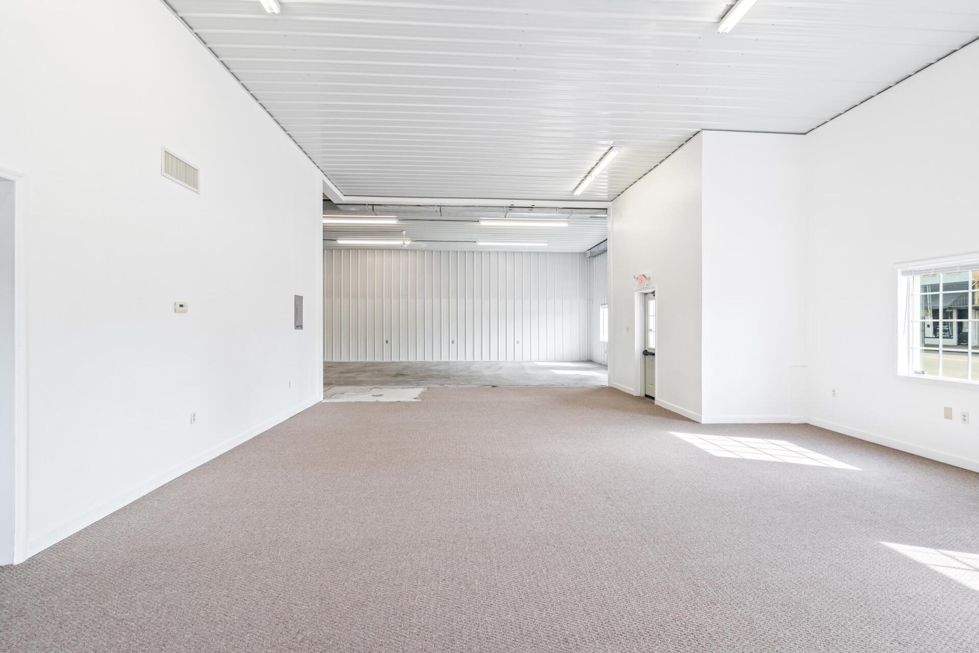 A large empty room with a carpeted floor and white walls.