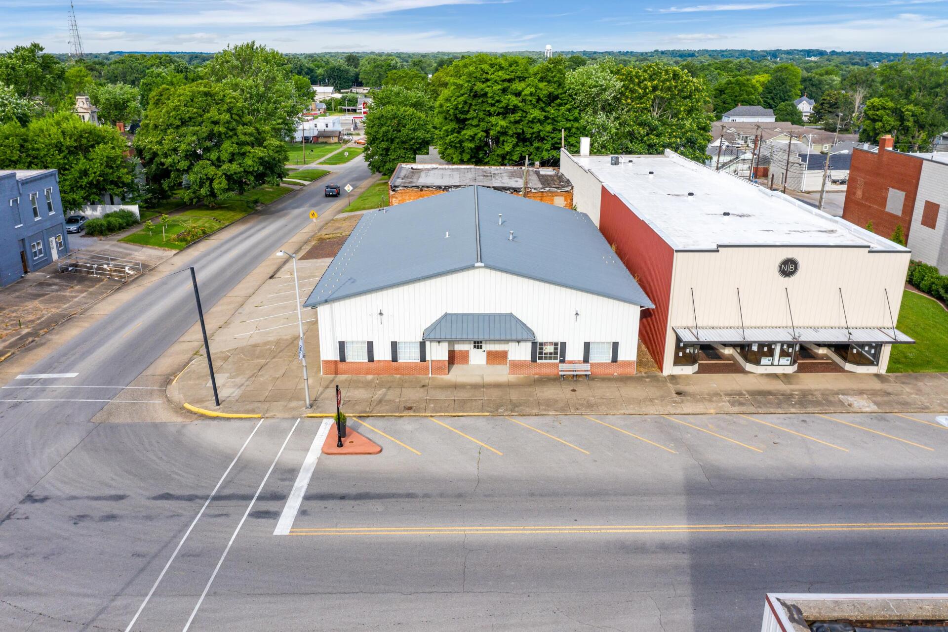 An aerial view of a building with a parking lot in front of it.