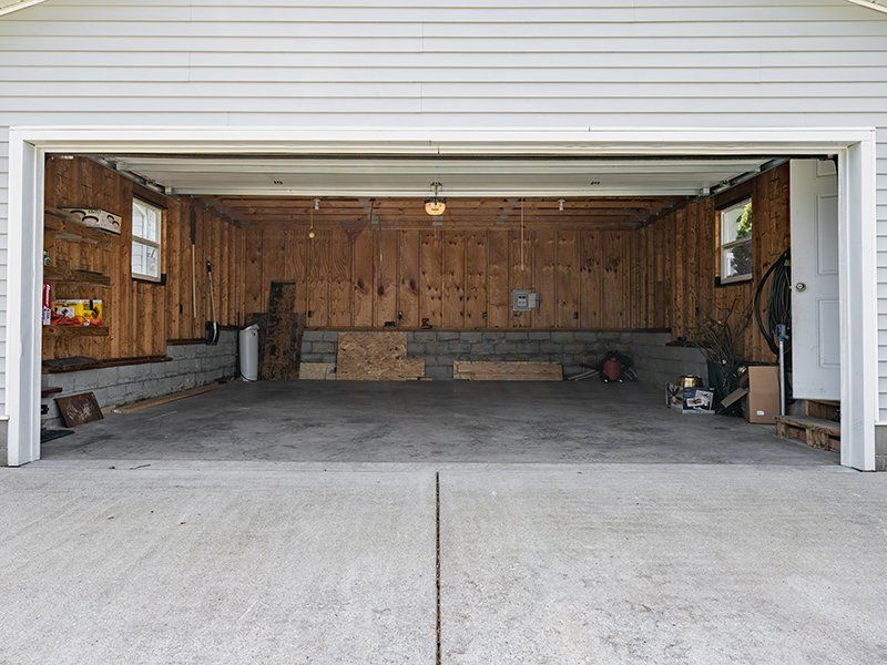 An empty garage with wooden walls and a concrete floor.