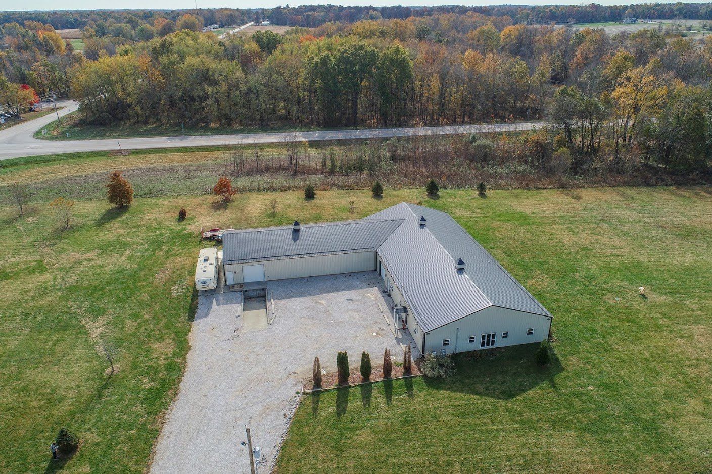 An aerial view of a house in the middle of a grassy field.