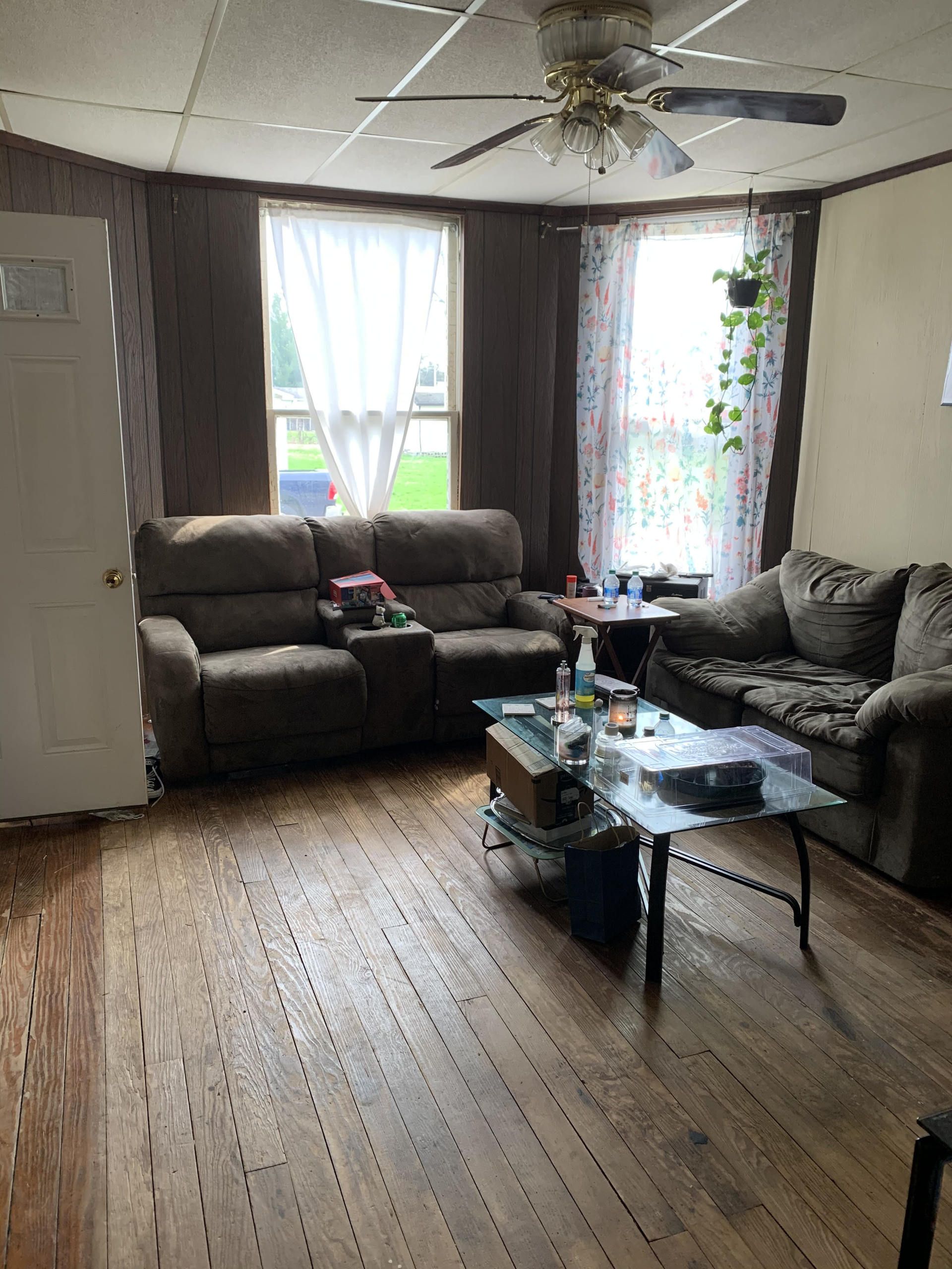 A living room filled with furniture and a ceiling fan.