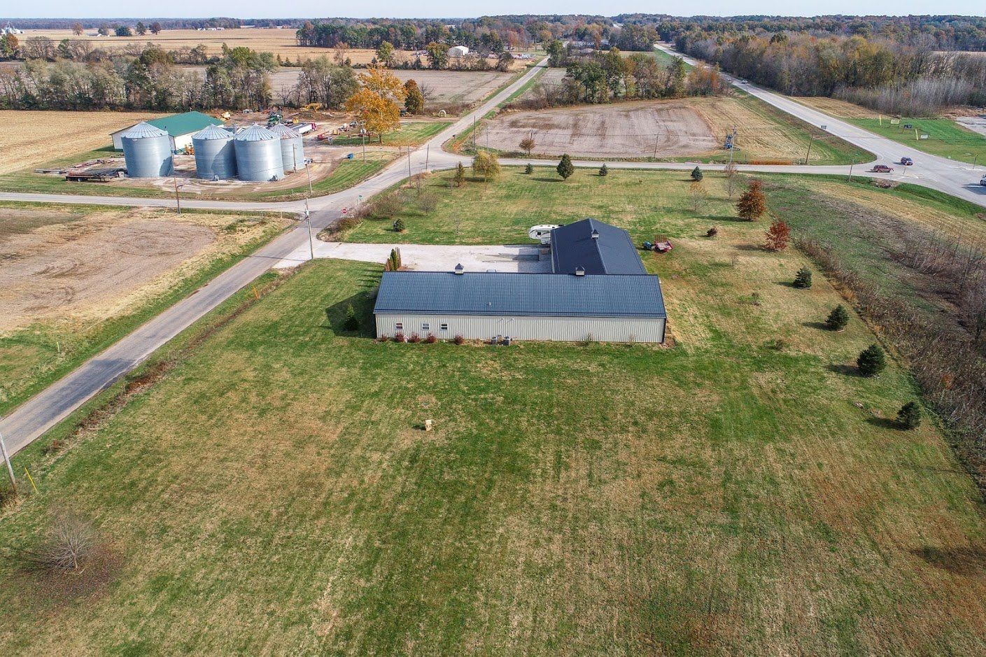 An aerial view of a farm with a house in the middle of a field.