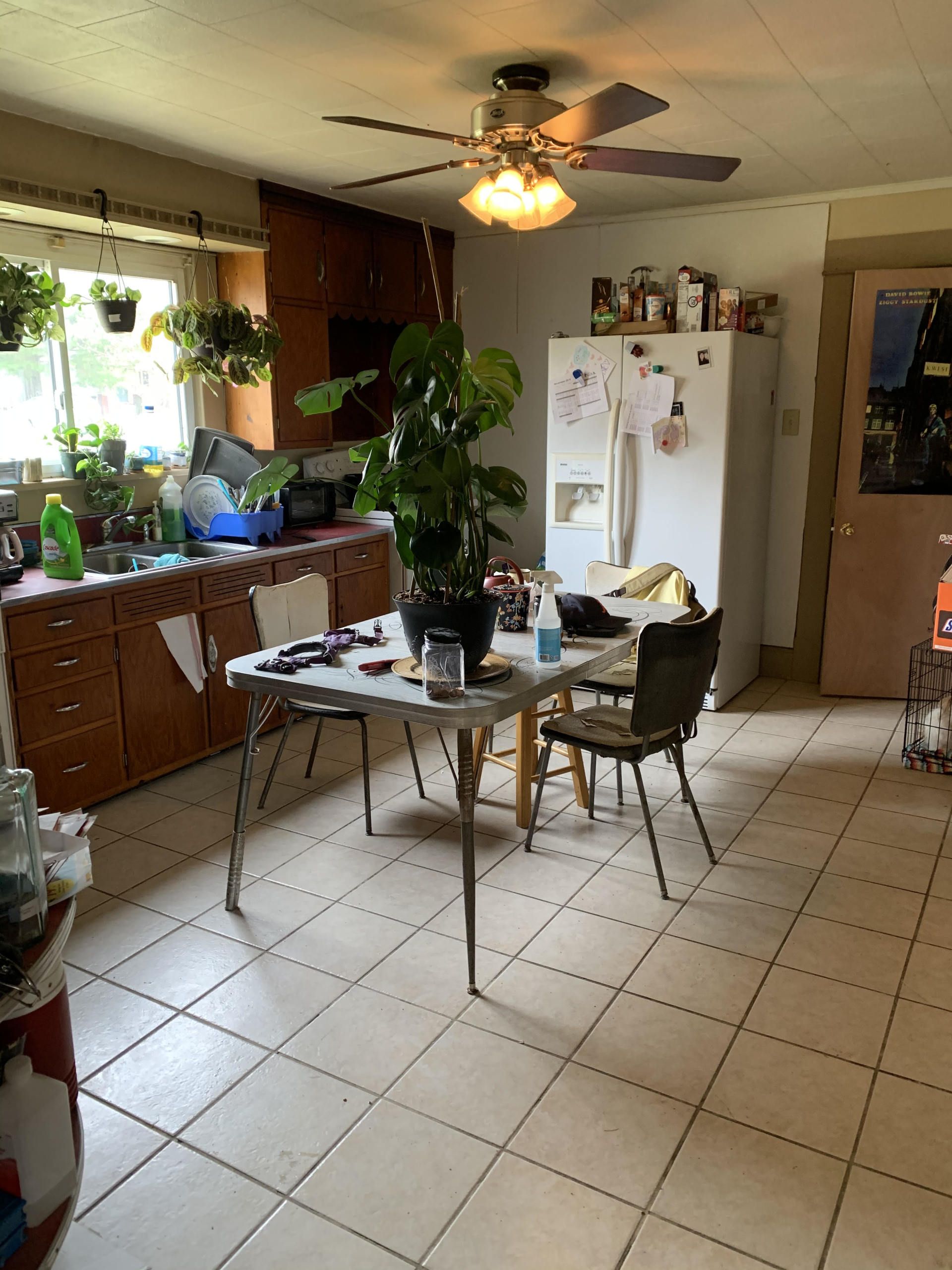 A kitchen with a table and chairs and a ceiling fan