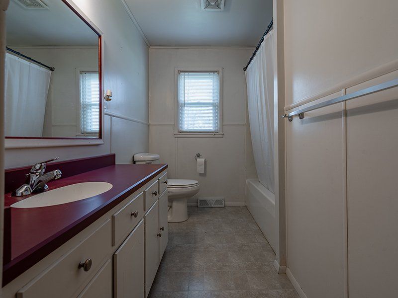 A bathroom with a toilet , sink and mirror