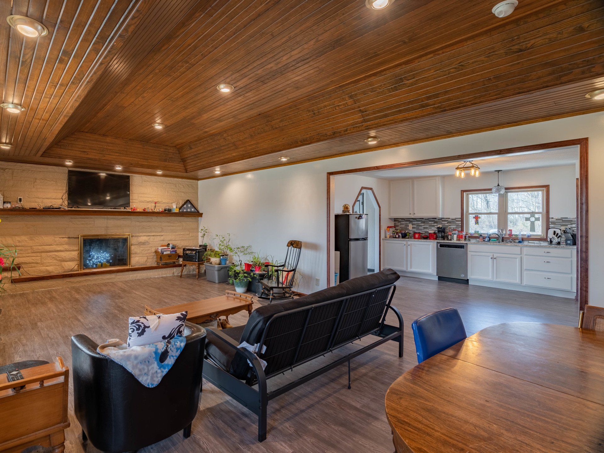 A living room with a couch , chairs , a table and a fireplace.