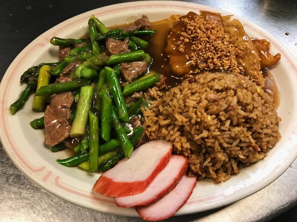 A red plate topped with rice and meat on a table.
