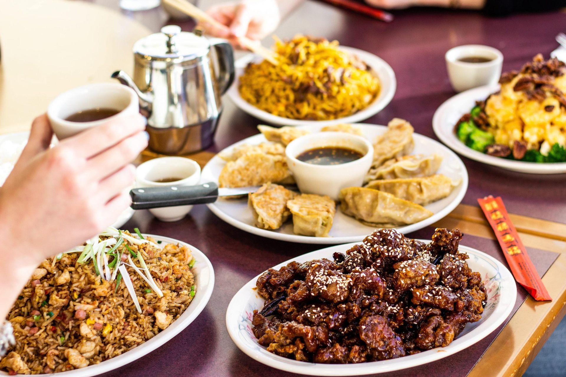 A close up of a plate of food with rice and spring rolls on a table.