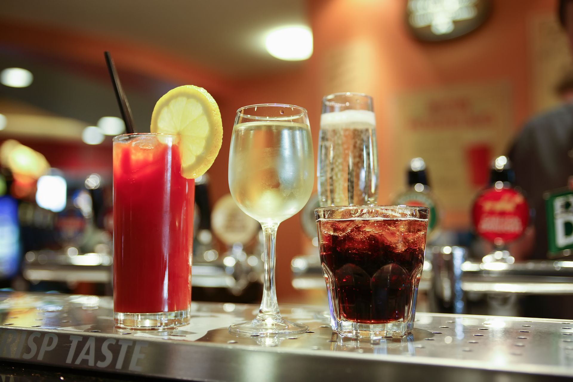 A bar with a few drinks on it and a sign that says sp taste