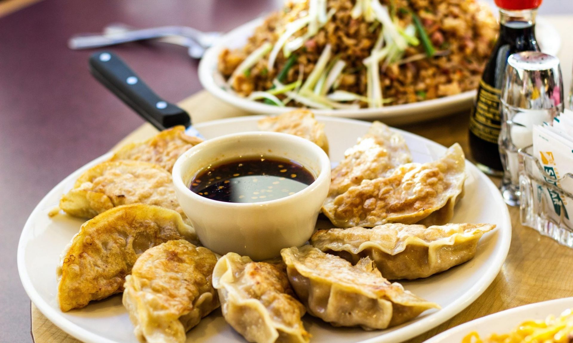 A close up of a bowl of rice and meat with chopsticks.