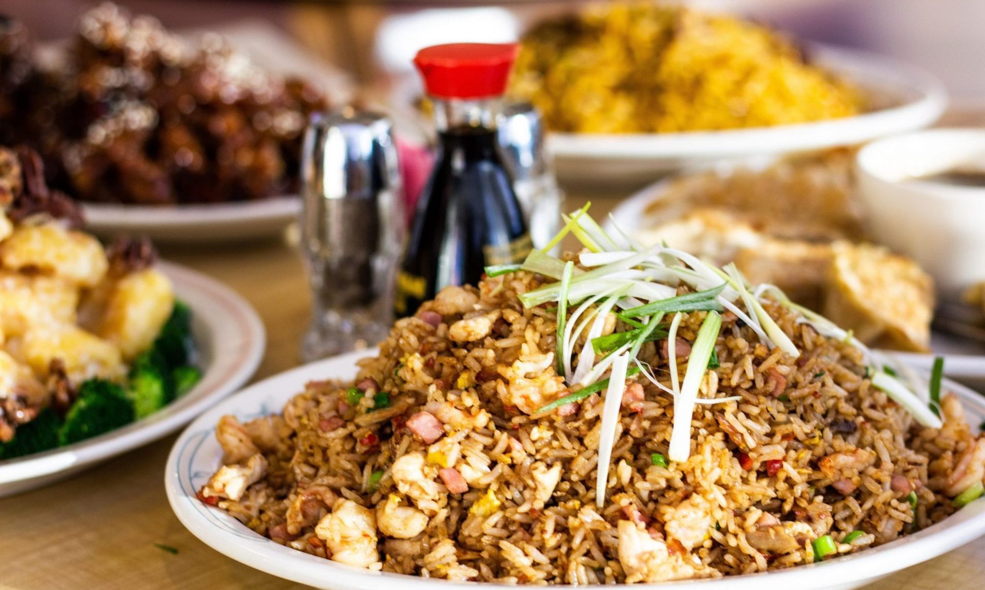A white plate topped with chicken and green onions on a red background.