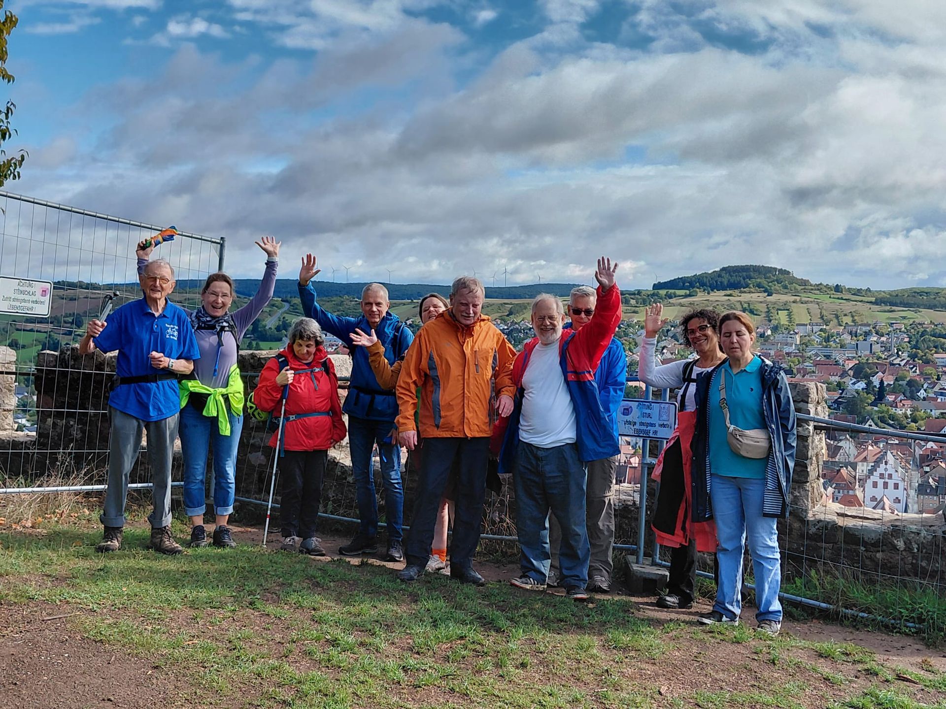 Ausflugsgruppe steht an einem Aussichtspunkt mit Blick über eine Stadt.