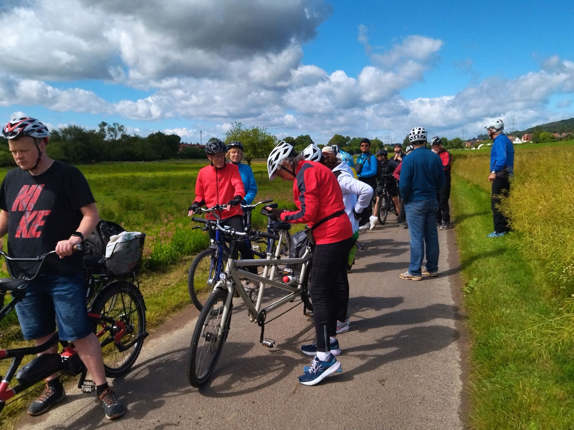 Eine Gruppe von Menschen fährt mit Fahrrädern eine Straße entlang.