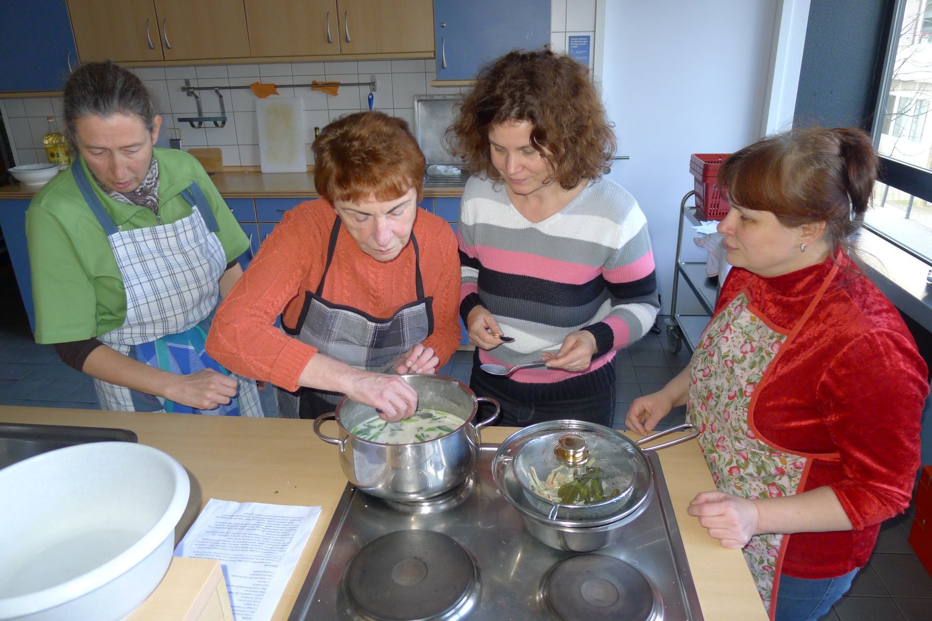 Eine Gruppe von Frauen bereitet in einer Küche Essen zu.