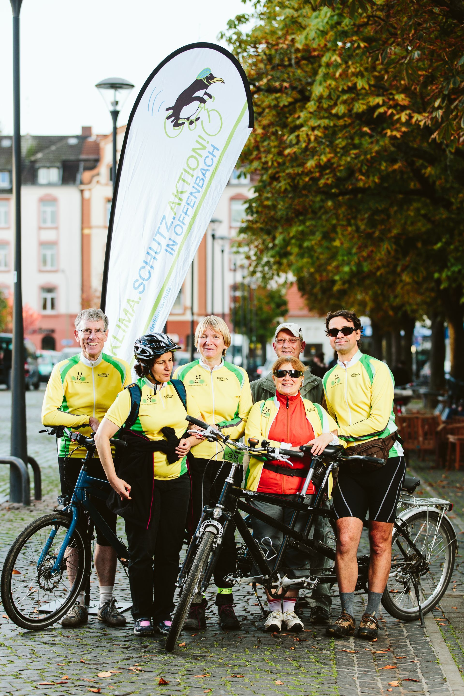 Eine Gruppe von Menschen posiert mit ihren Fahrrädern für ein Foto.