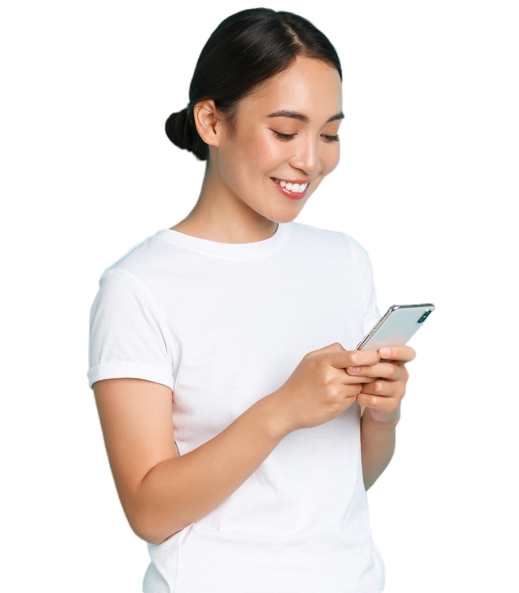 A woman in a white shirt is smiling while looking at her cell phone