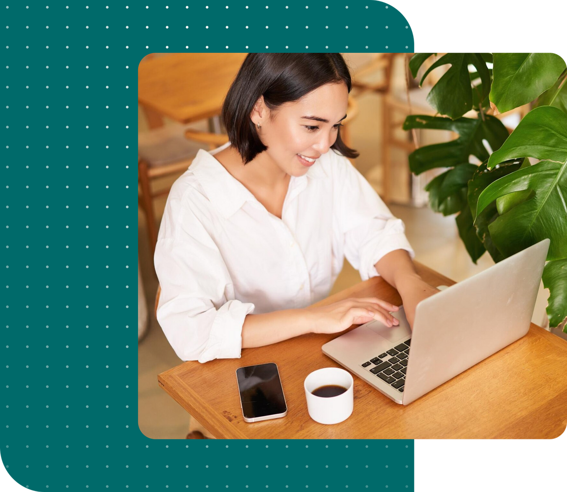 A woman is sitting at a table using a laptop computer.