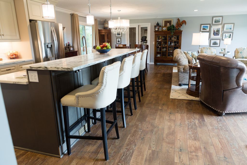 Open kitchen with a large island, bar stools, and living area.