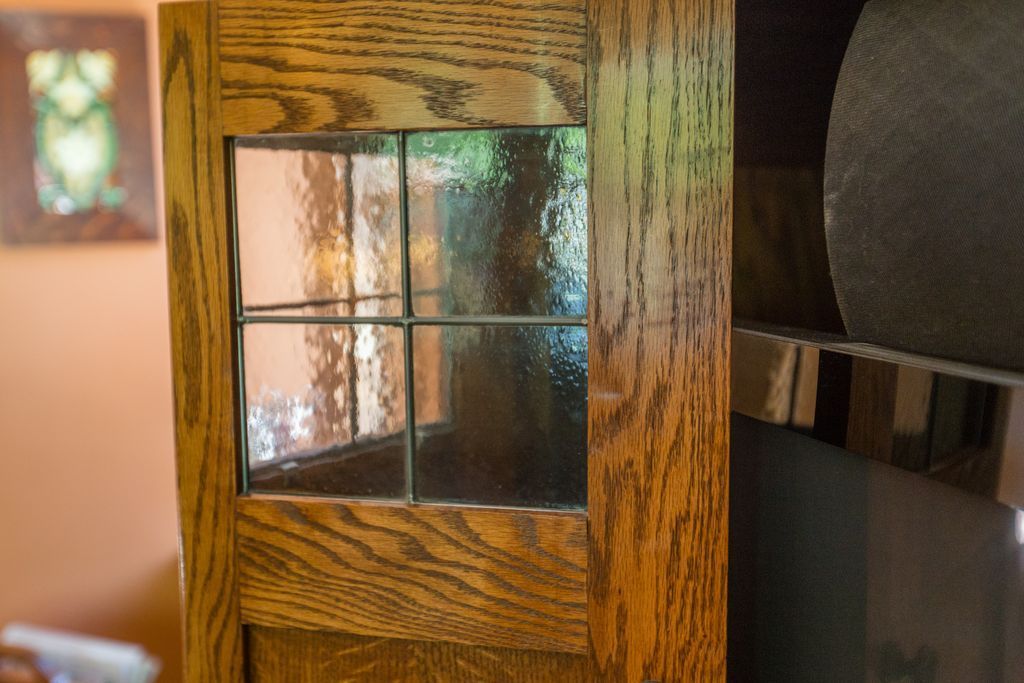 Wooden door with paneled glass, showcasing an interior room with a painting.