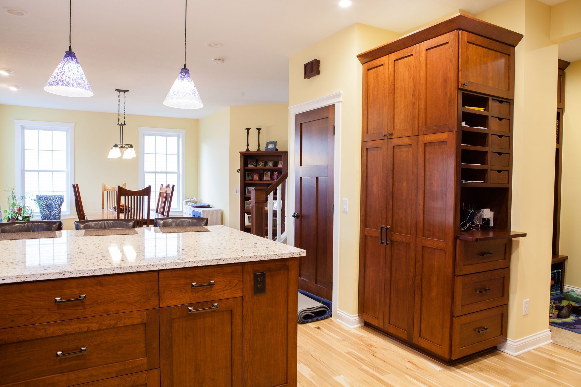Kitchen with wooden cabinets, island, wine rack, and a dining area.