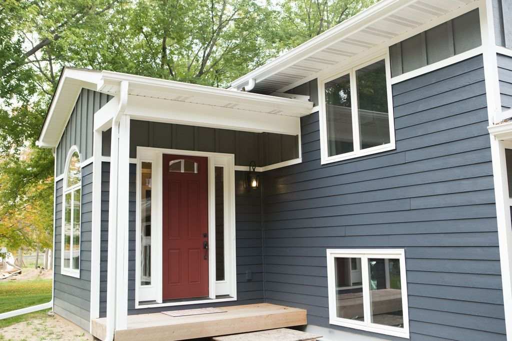 Gray house exterior with red door, white trim, and small porch.
