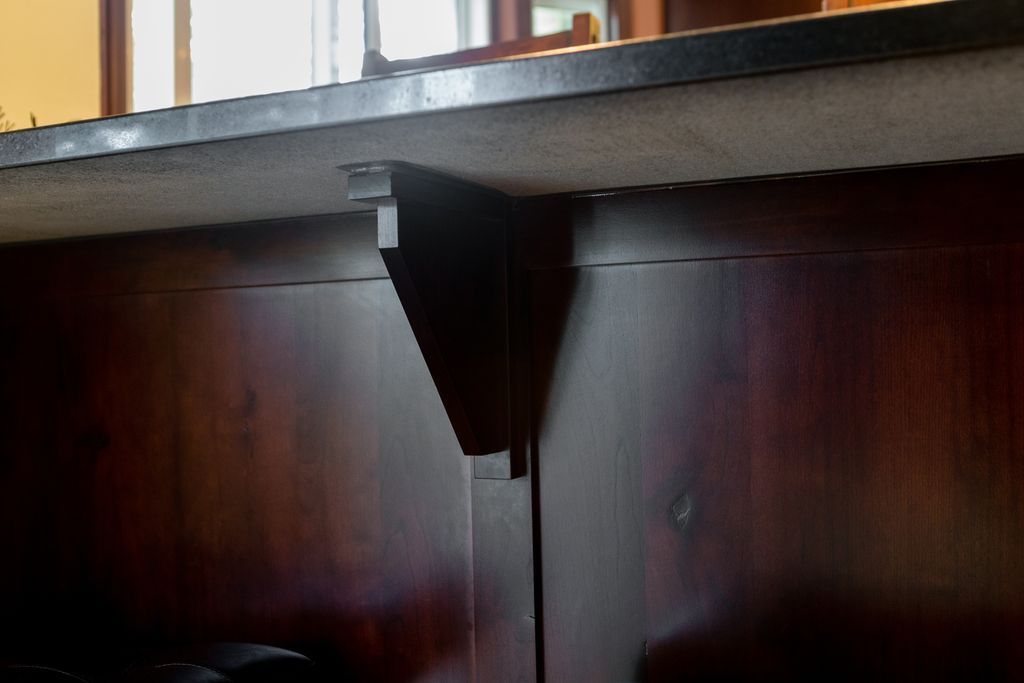 Dark wood bar with a triangular bracket for support.