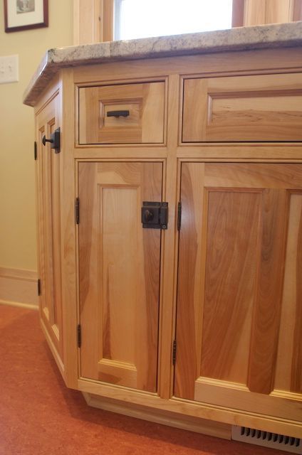 Light wood kitchen cabinets with dark hardware.