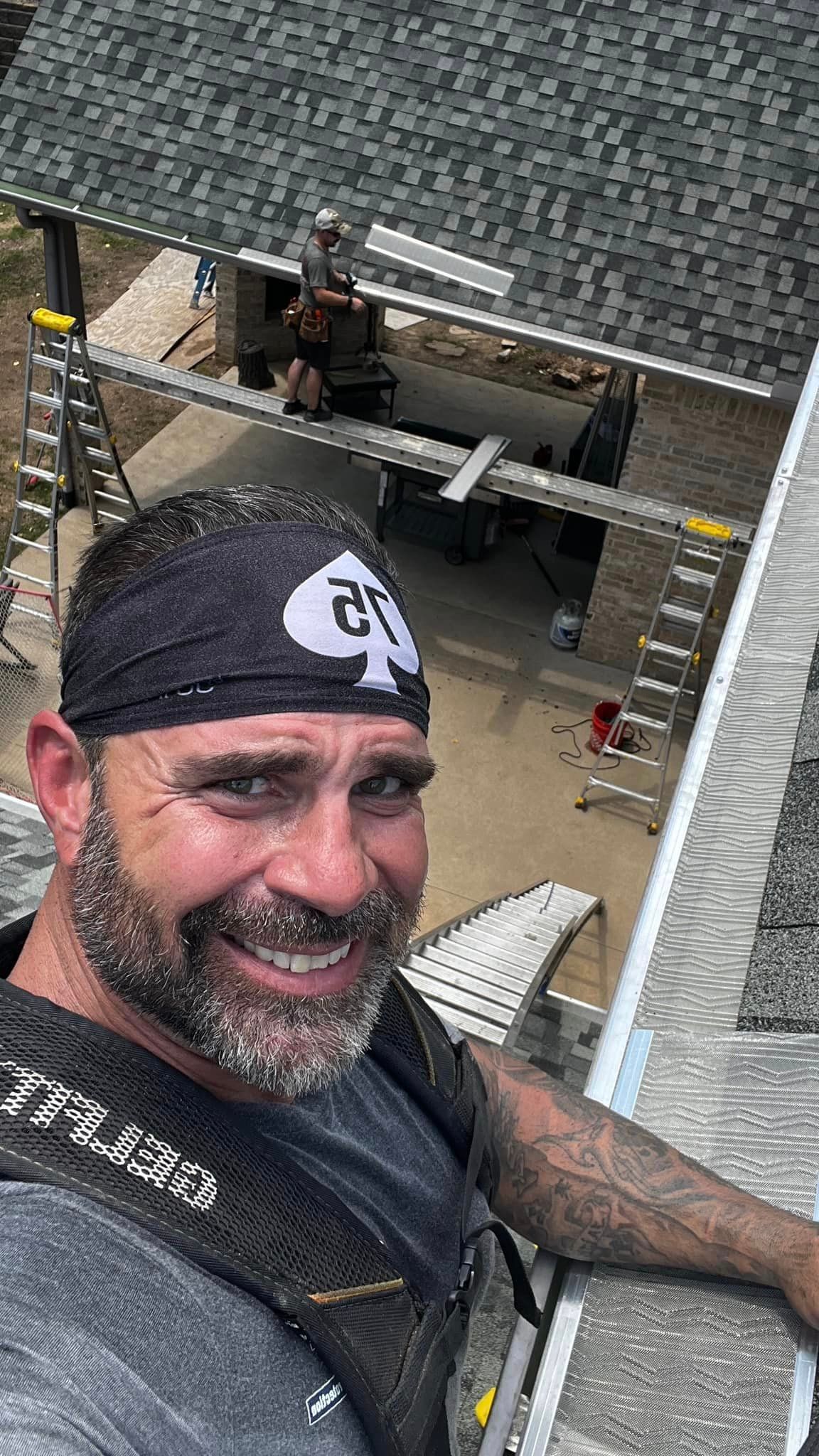 Michael Triska is standing on top of a roof installing gutters.