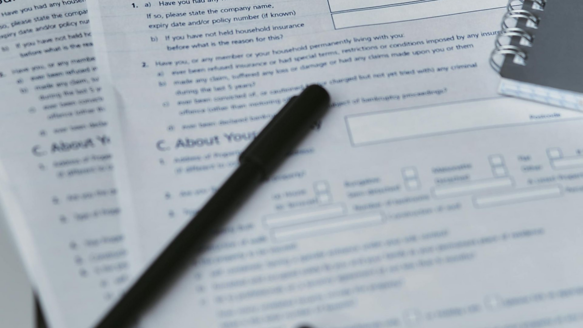 Papers with form fields, pen, and notebook.