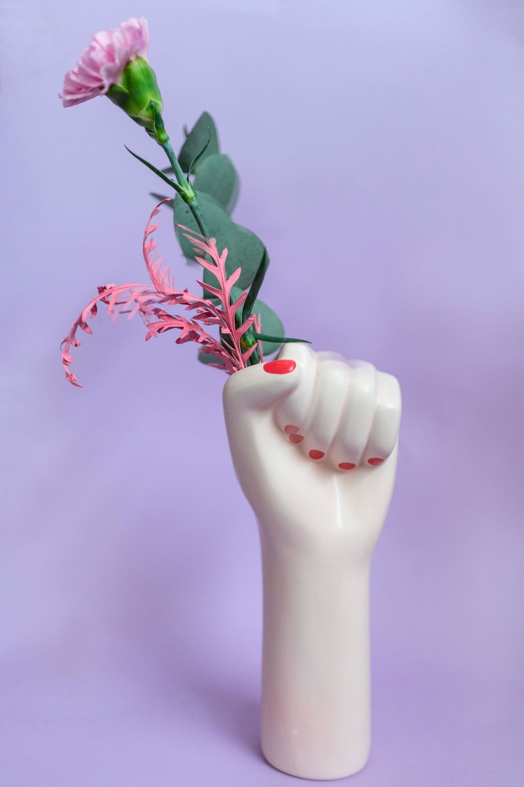 un vaso a forma di pugno con un fiore in esso .