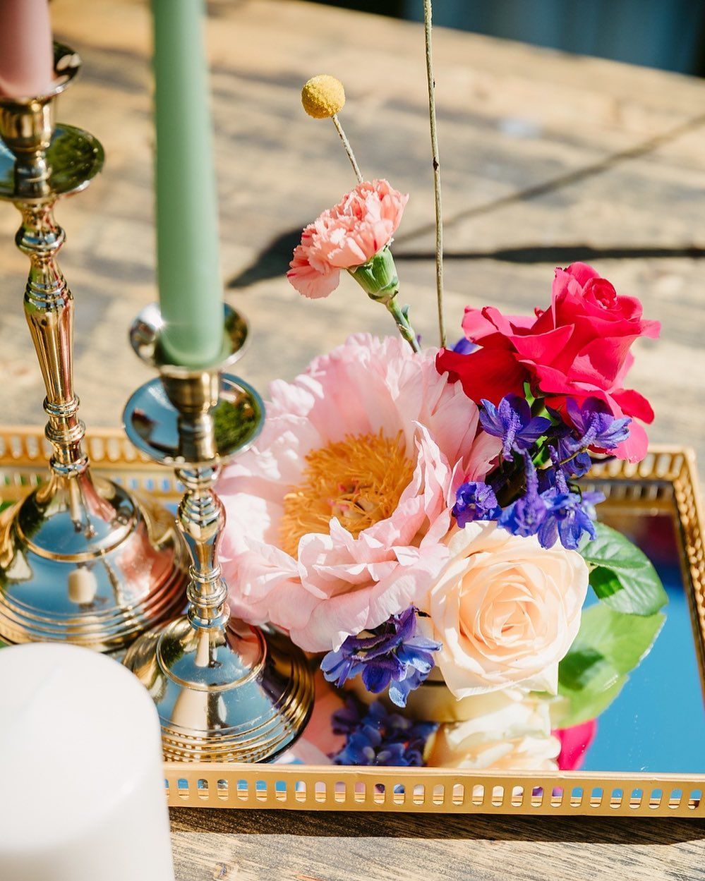 un vassoio pieno di fiori e una candela su un tavolo .