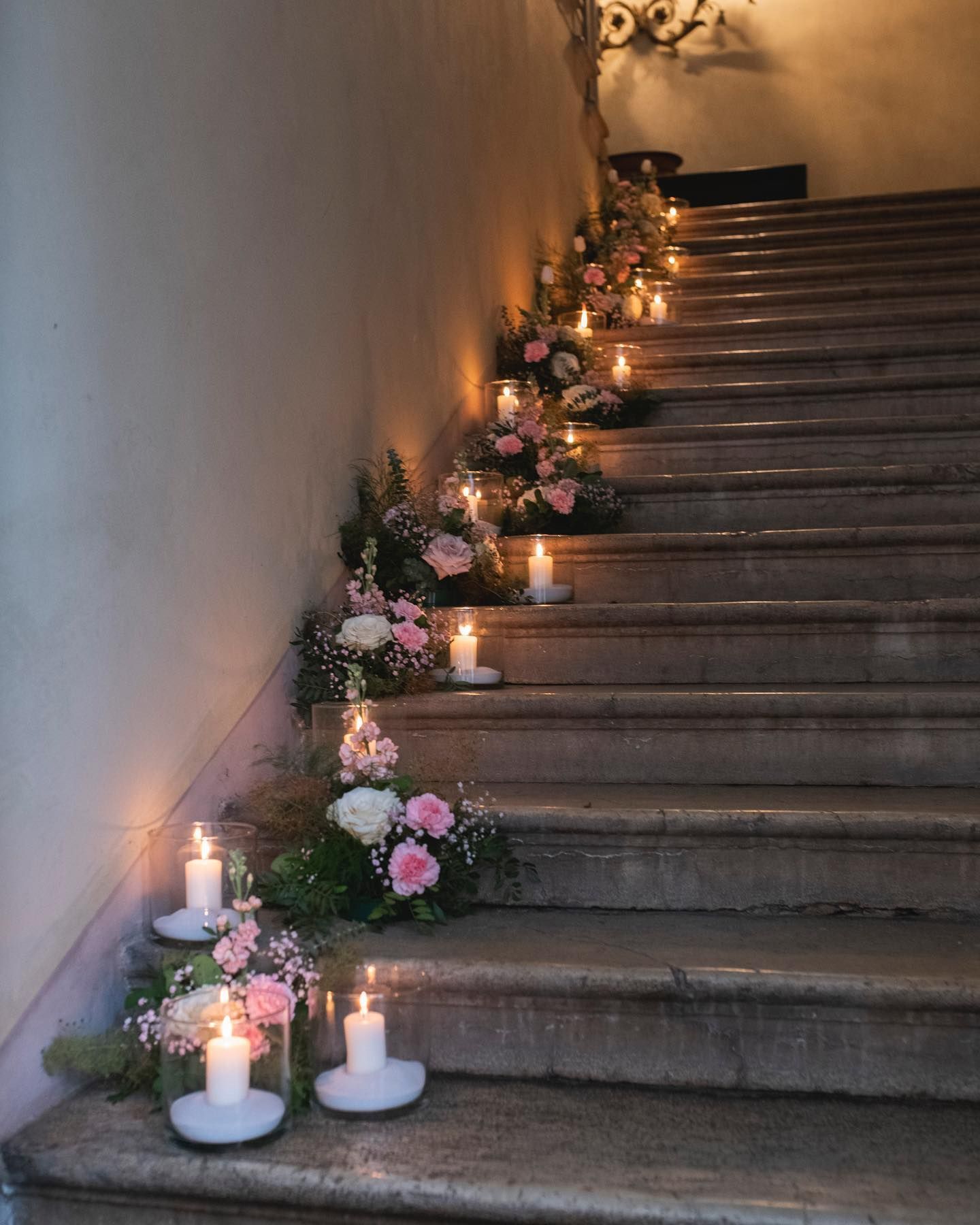 le scale sono decorate con candele e fiori rosa