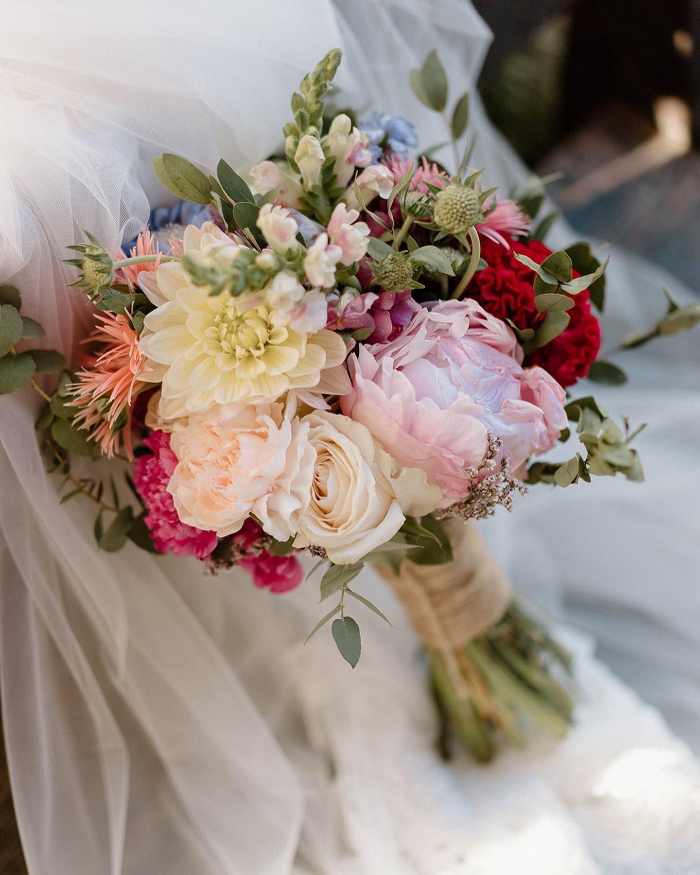 una sposa tiene in mano un bouquet di fiori colorati .