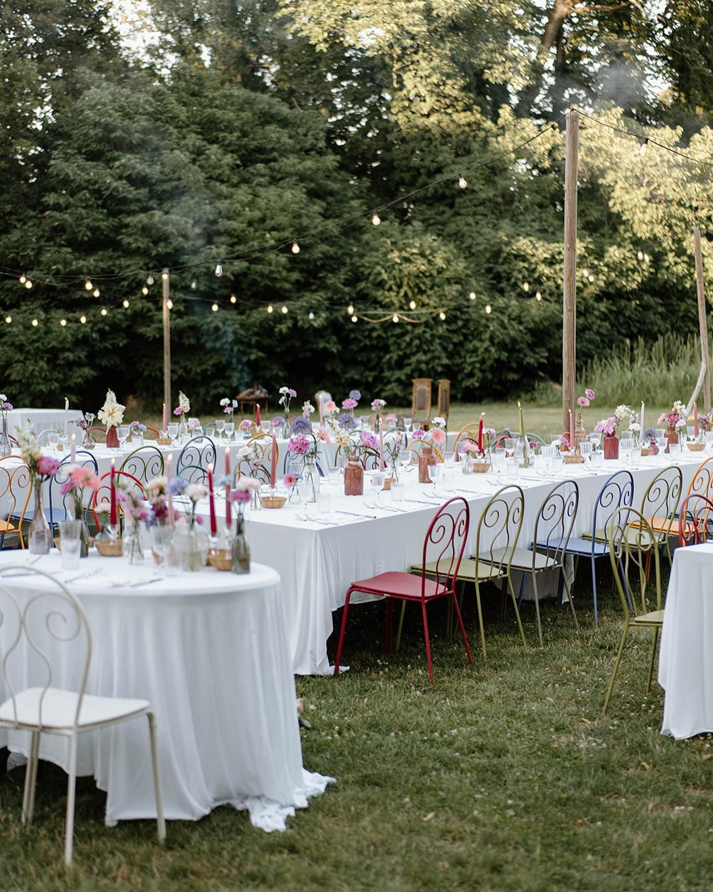 un prato pieno di tavoli e sedie per un matrimonio all'aperto .