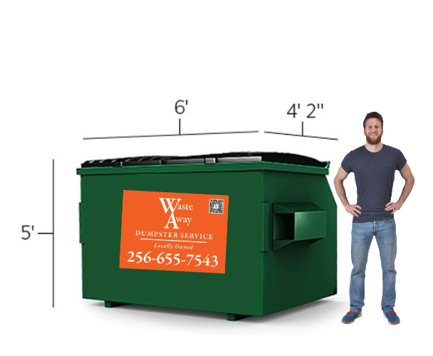 A man is standing next to a green dumpster.