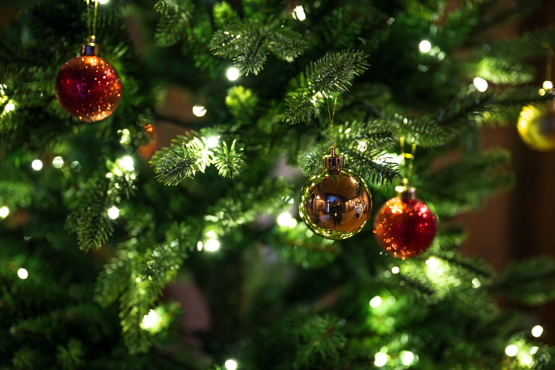 Juletre pyntet med julekuler og hvite lys.