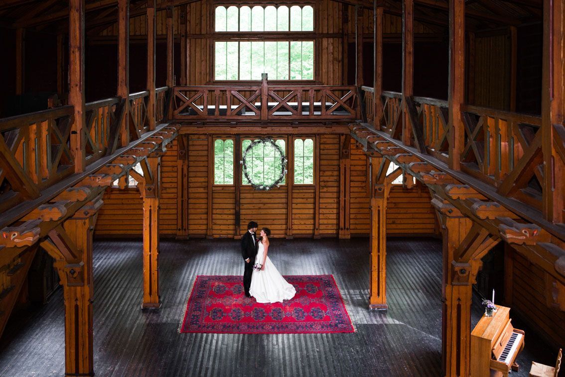 Paret står på et rødt teppe i en Gamle Landbruk; paret er i formelle antrekk, foran et vindu.